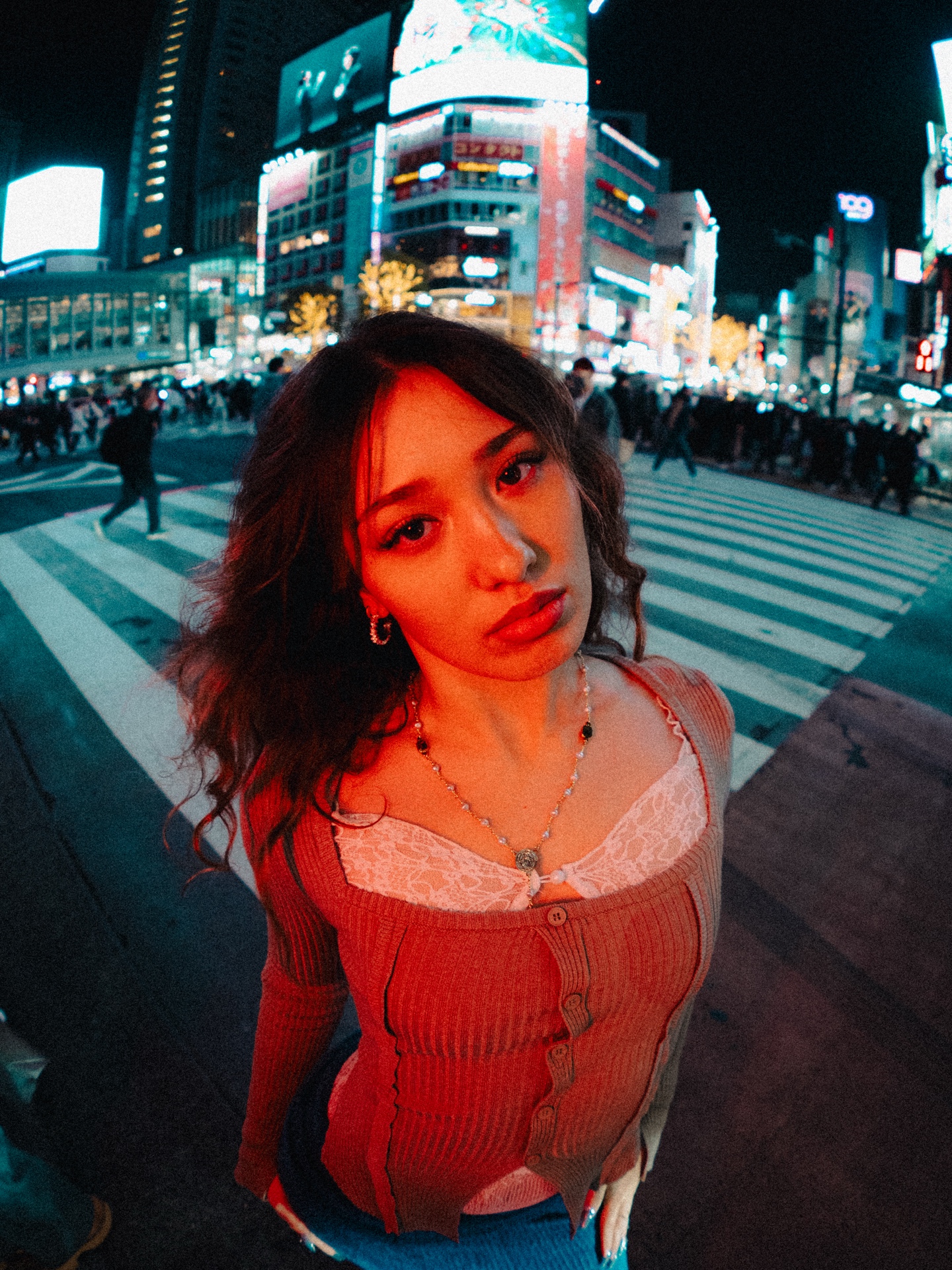 Red-lit portrait at Shibuya Crossing after dark